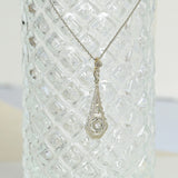 Collar Art Deco con un diamante central y un motivo delicado, elaborado en oro amarillo y blanco de 18K. Incluye 3 diamantes de corte rosa para una elegancia atemporal.