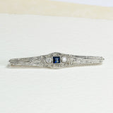 Antikes Brosche mit einem zentralen 0,31 ct Saphir und 16 Diamanten von insgesamt 0,17 ct, in 14K Weißgold.