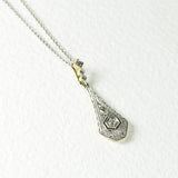 Art Deco necklace with a central diamond and delicate motif, crafted in 18K yellow and white gold. Features 3 rose cut diamonds for timeless elegance.