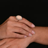 Angel skin coral Ring with a diamond halo.