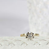 Solitaire star diamond ring with a central round cut diamond set in 18K white gold. Elegant star shape design.