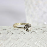 Anillo solitario con forma de estrella, con un diamante central redondo en oro blanco de 18K. Diseño elegante en forma de estrella.