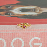 Anillo vintage de rubí y diamantes en oro amarillo de 14K, con un rubí redondo en el centro y dos diamantes.