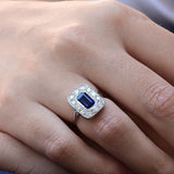 Anillo vintage con un zafiro octagonal central y 12 diamantes en corte brillante en oro blanco de 18k.
