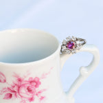 Anillo vintage en forma de flor con rubí central y ocho diamantes naturales en oro blanco de 14K.