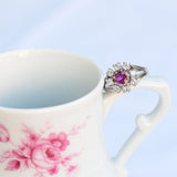 Anillo vintage en forma de flor con rubí central y ocho diamantes naturales en oro blanco de 14K.