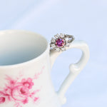Bague vintage en forme de fleur avec un rubis central et huit diamants naturels en or blanc 14K.