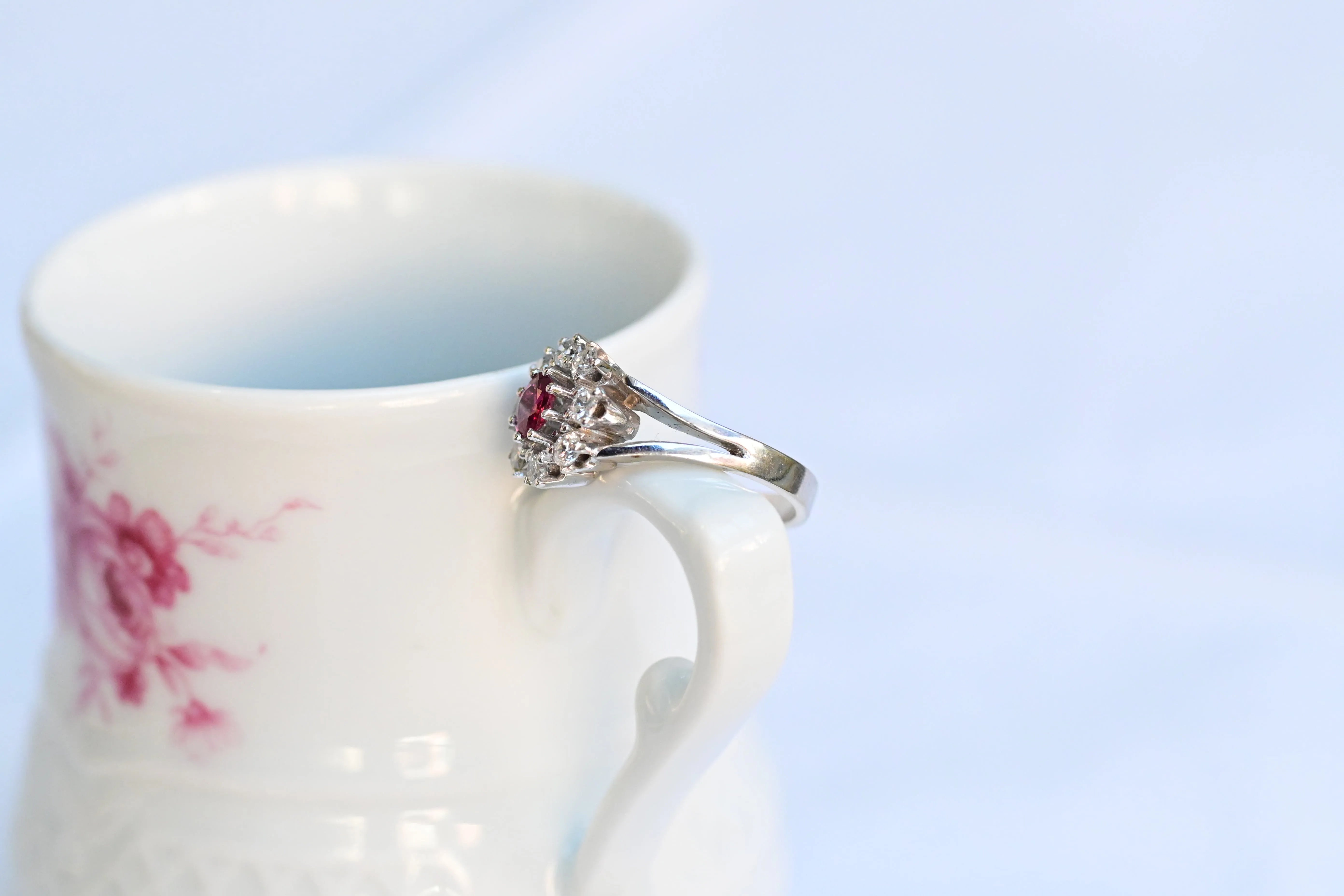 Vintage Blütenring mit zentralem Rubin und acht natürlichen Diamanten in 14K Weißgold.