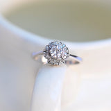 Verlobungsring mit rundem Diamanten in 18K Weißgold und 14 umliegenden Diamanten.