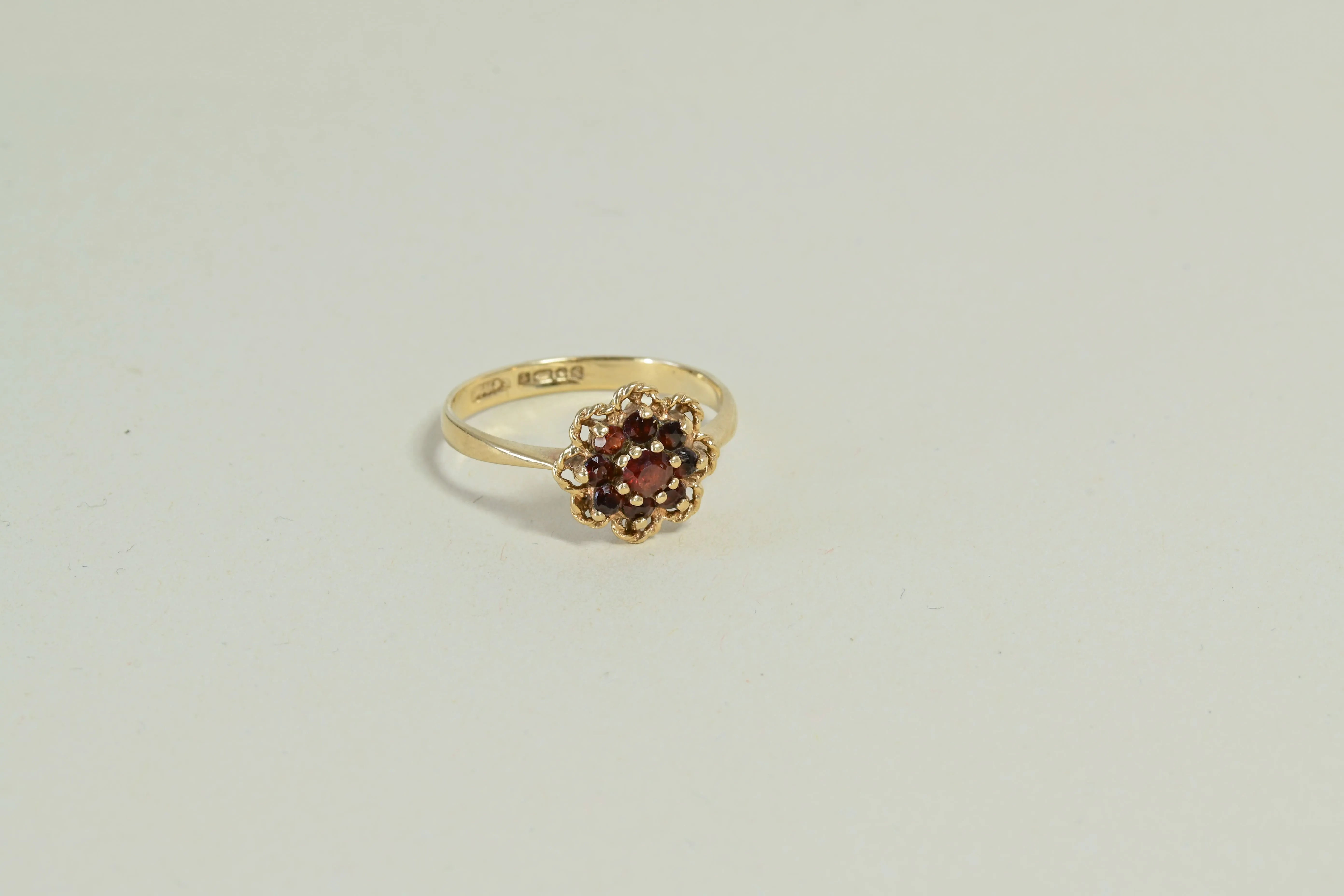 Anillo de rosetón estilo isabelino con granates en oro amarillo.