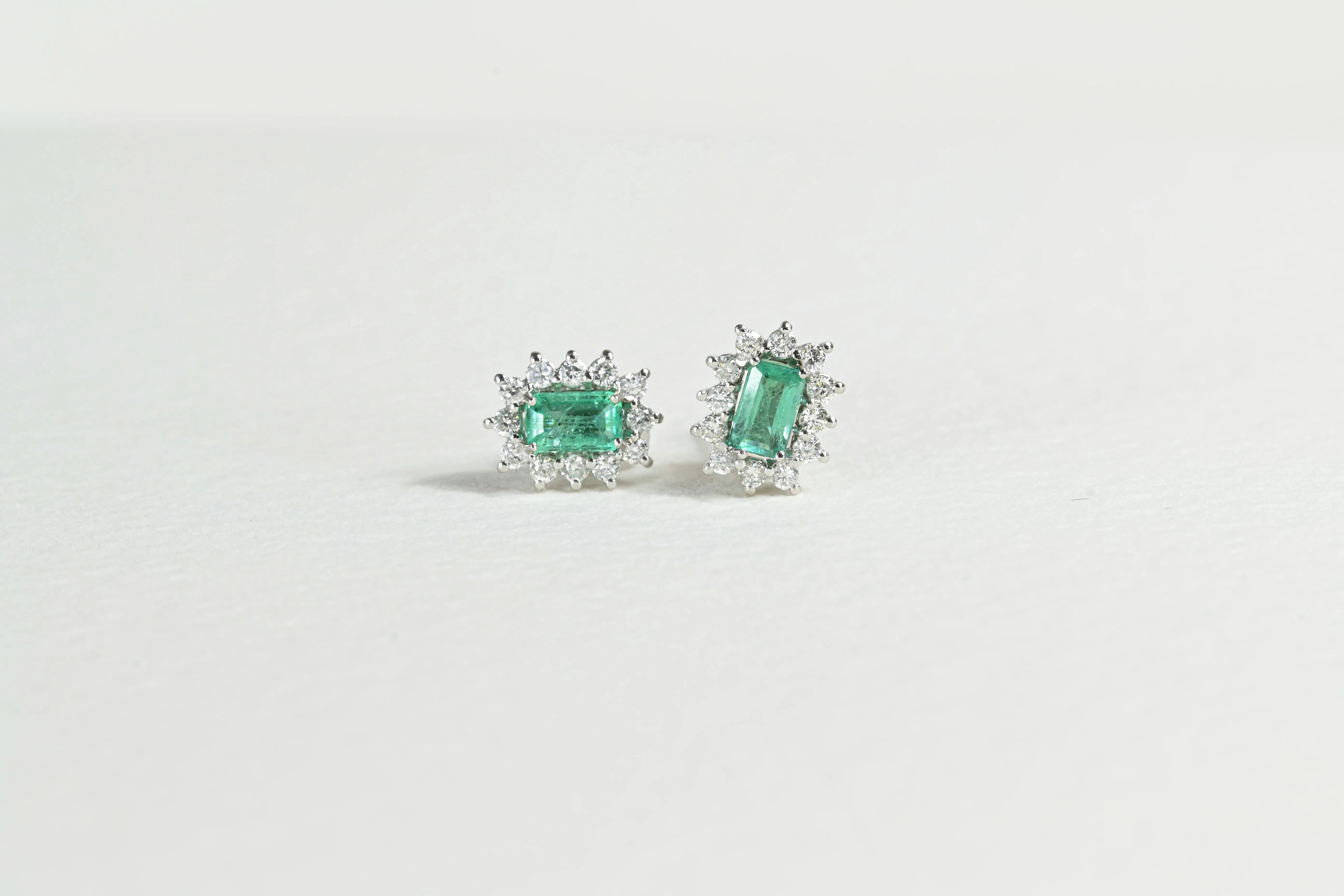 Boucles d'oreilles en émeraude avec un halo de 12 diamants.