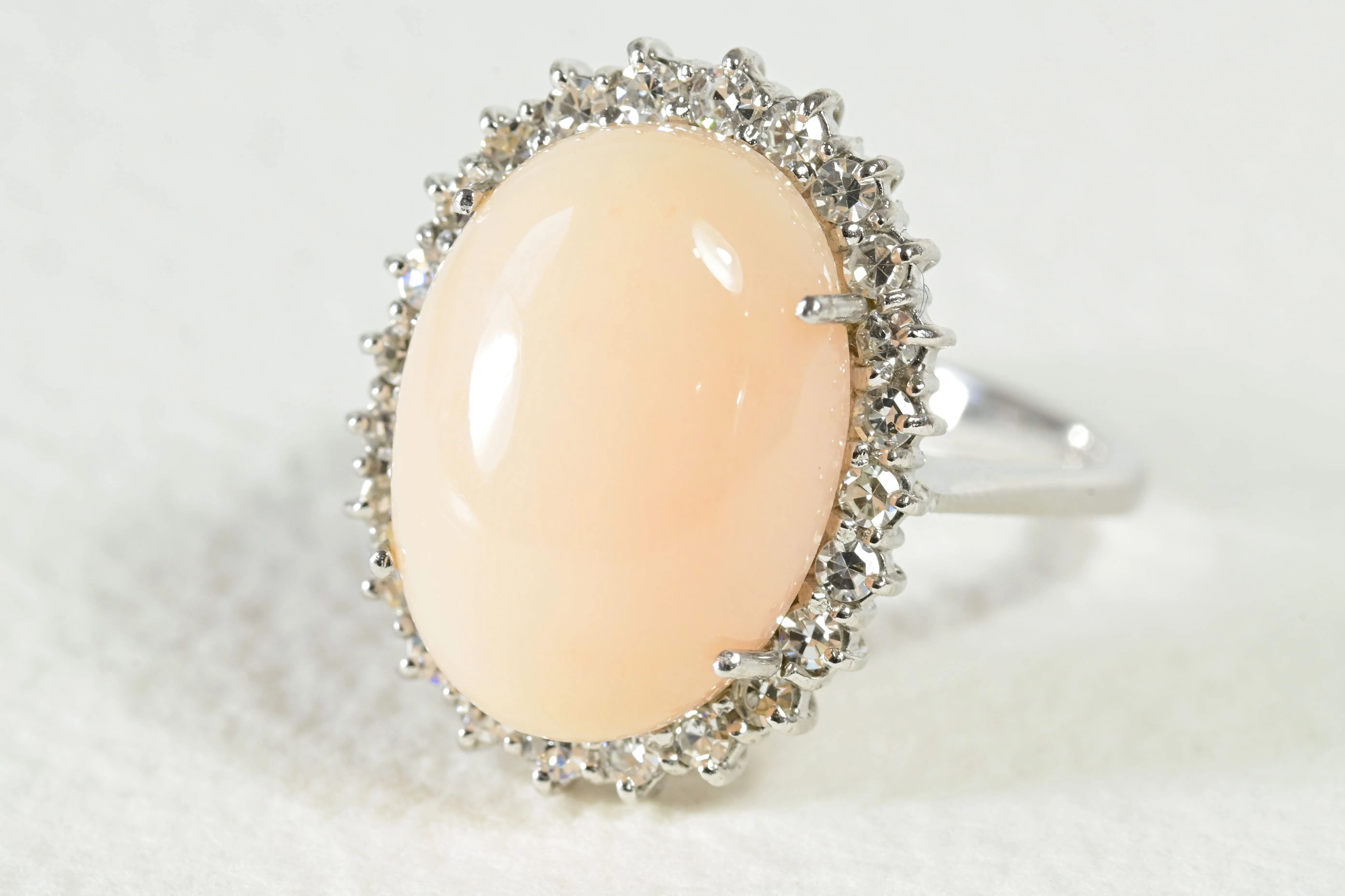 Anillo de coral piel de ángel con un halo de diamantes.