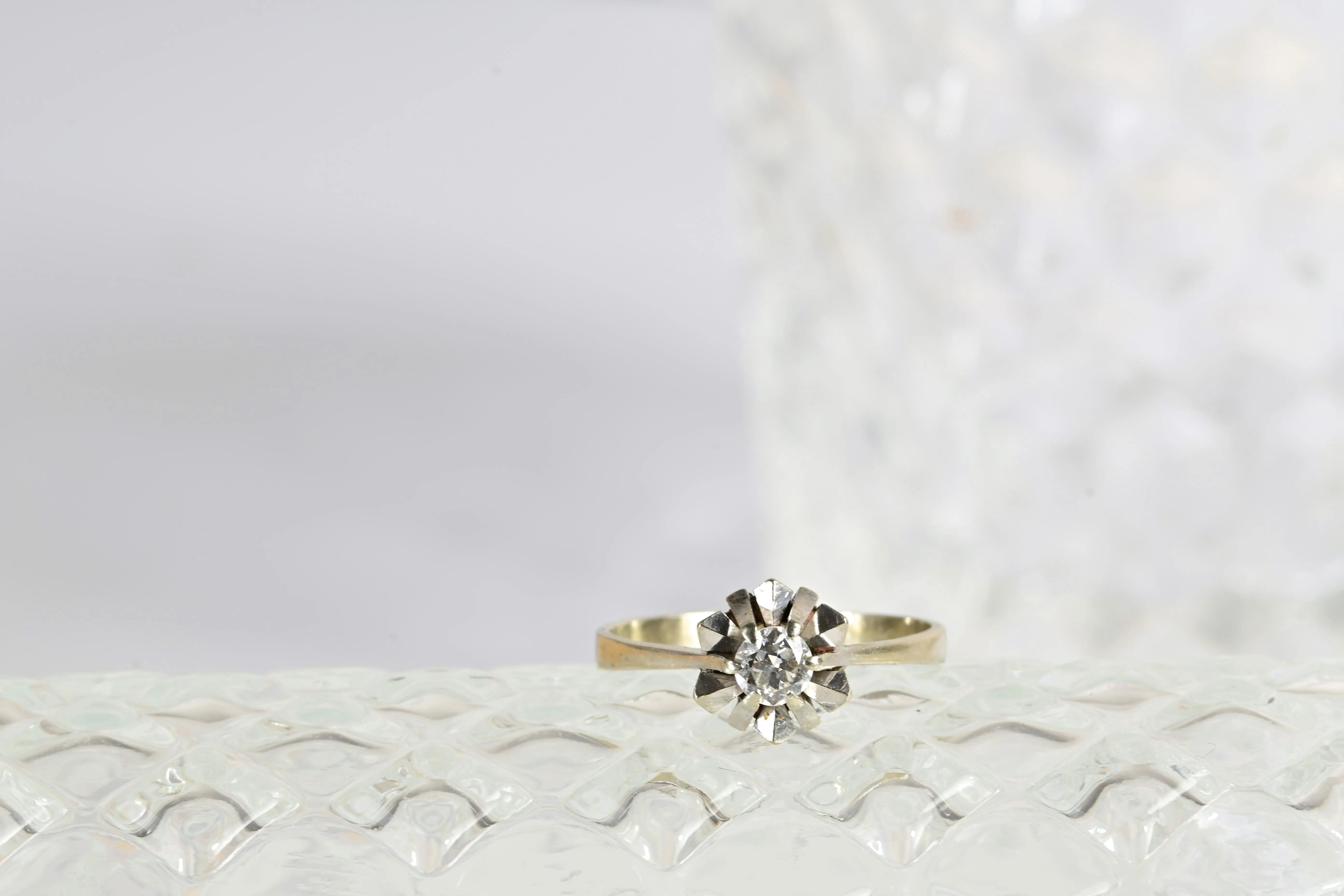 Solitaire star diamond ring with a central round cut diamond set in 18K white gold. Elegant star shape design.