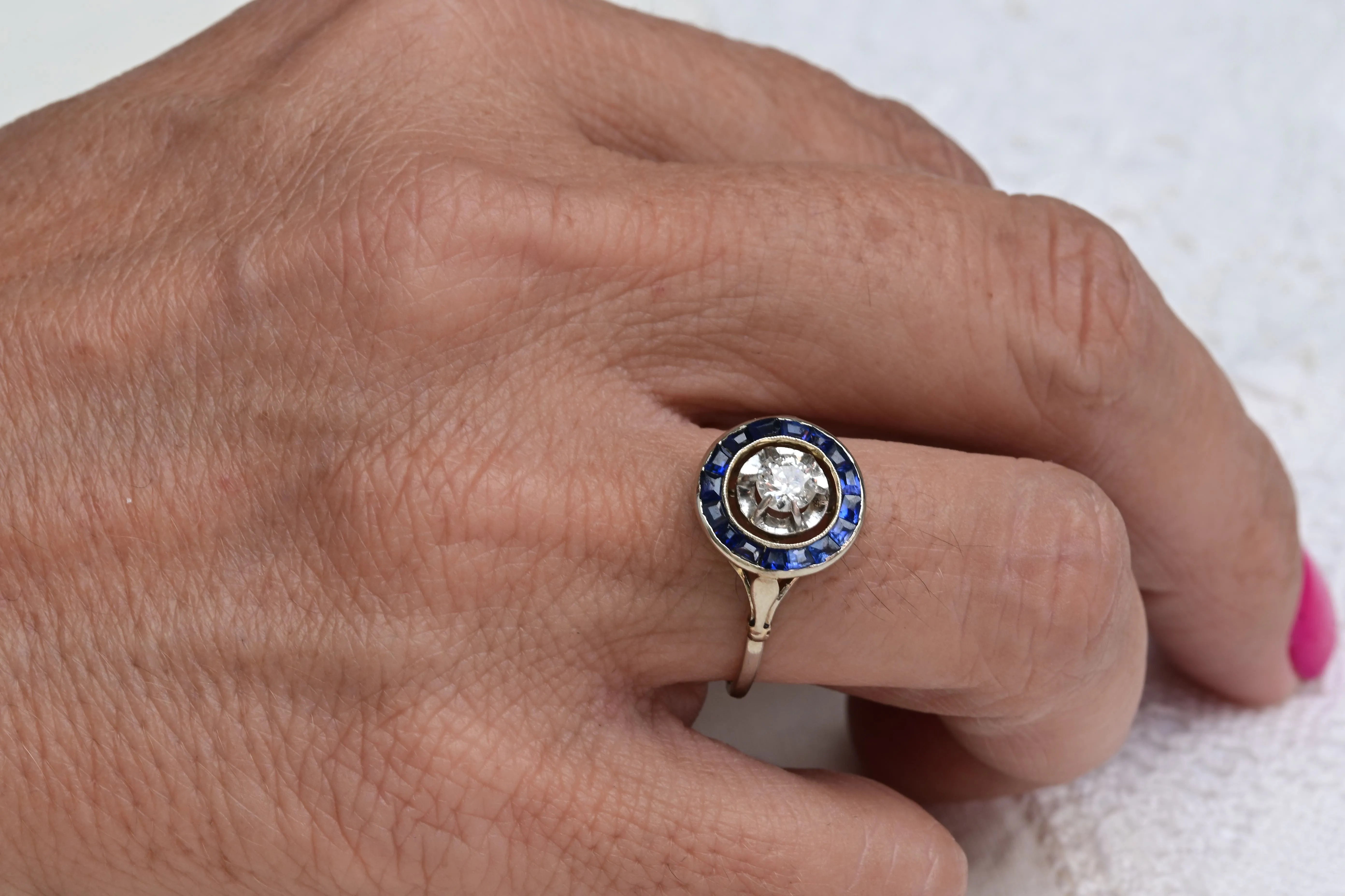 Partridge Eye ring from 1920 with a central European old brilliant cut diamond and 16 carré cut sapphires in 18K white gold.