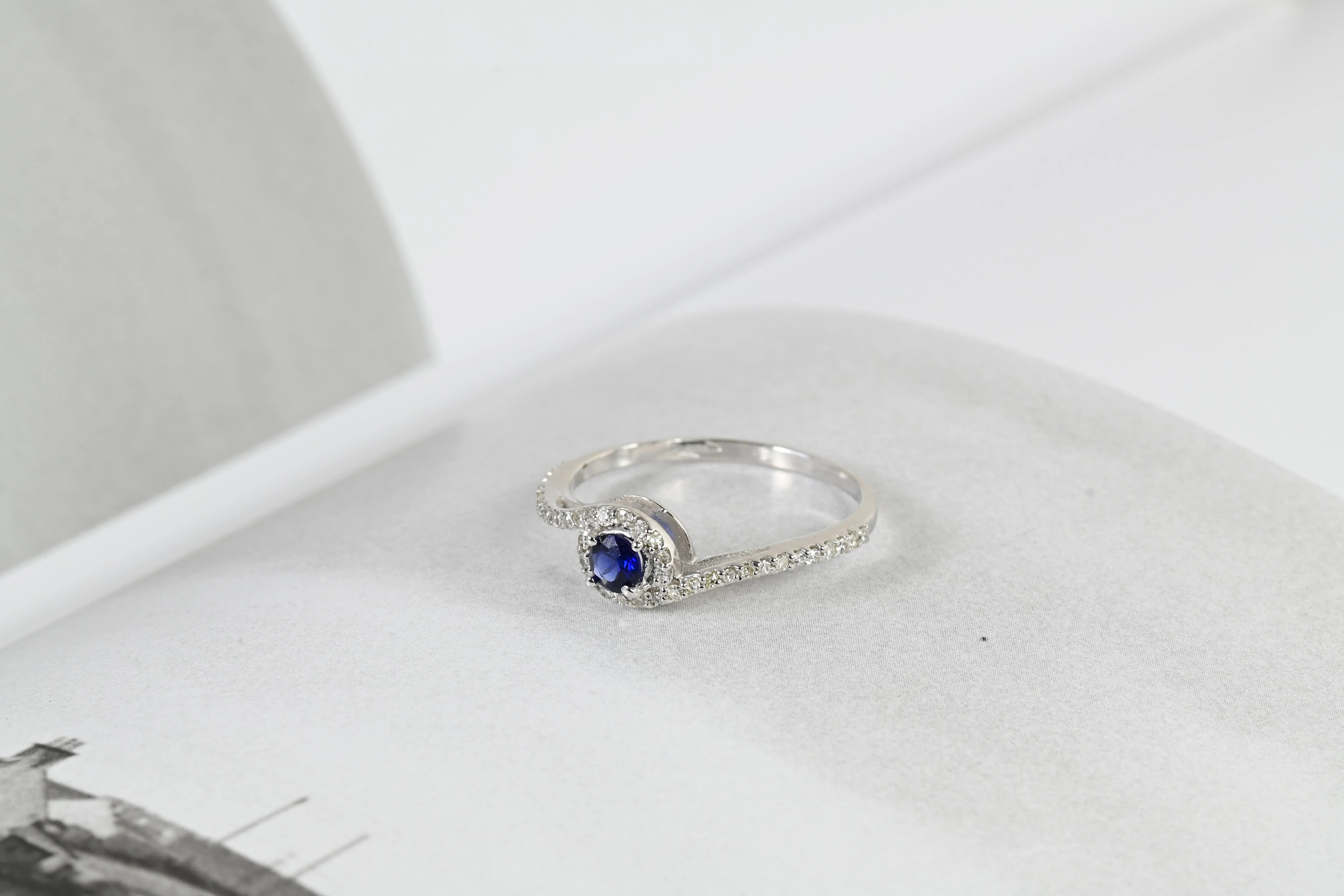 Vintage-Ring mit einem tiefblauen Saphir in der Mitte und einem Halo aus 44 Diamanten, in 18K Weißgold gefasst.