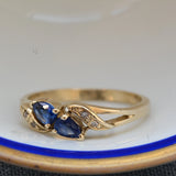  Deslumbrante anillo vintage que presenta dos zafiros en corte pera de tonos azules profundos, complementados por cuatro brillantes diamantes. Una pieza de elegancia atemporal perfecta para ocasiones especiales.