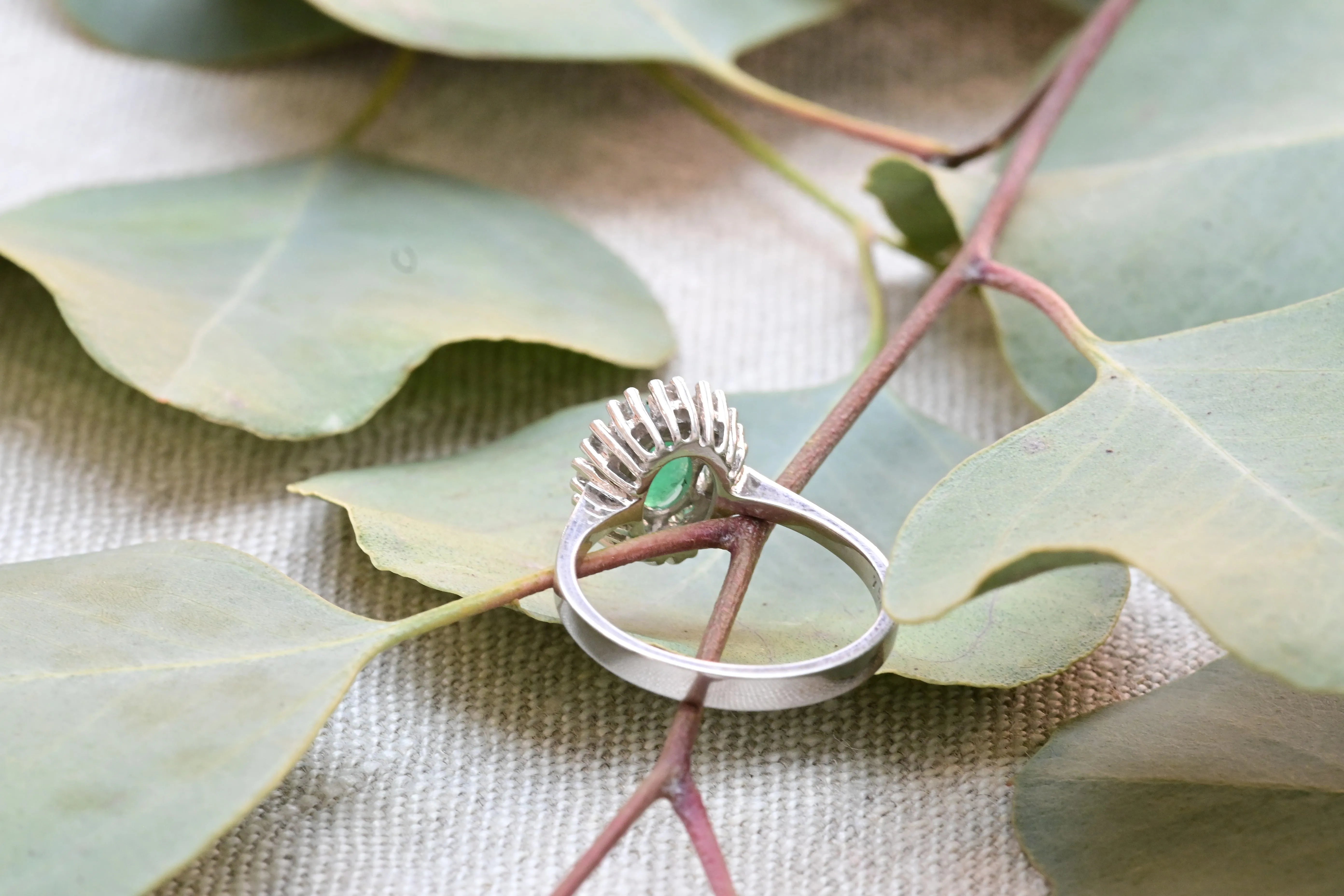 Bague cocktail vintage avec une émeraude centrale taillée en ovale et 12 diamants.