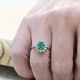 Vintage cocktail ring with a central oval cut emerald and 12 diamonds.