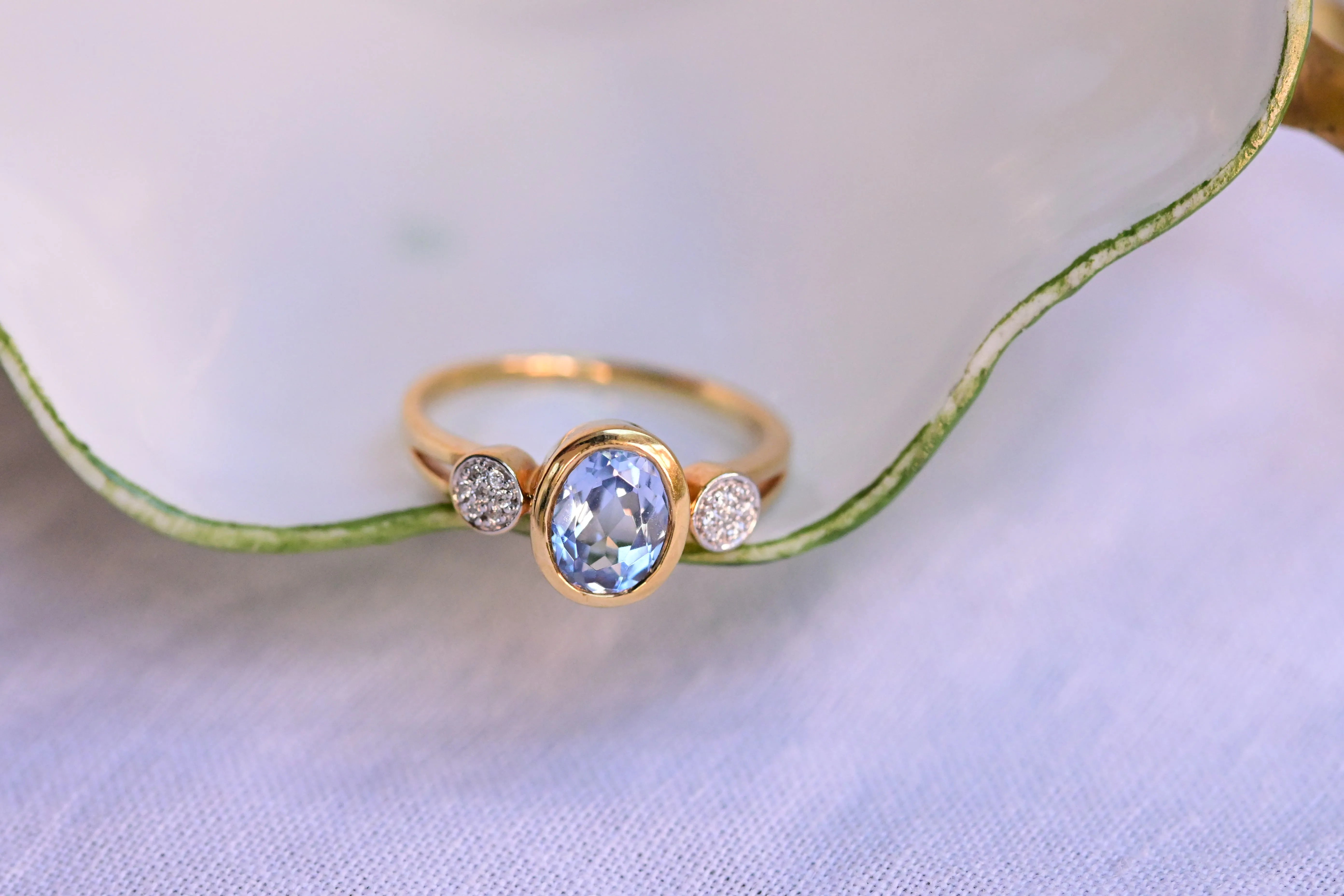 Vintage ring with a central blue topaz and 14 zircons in bezel setting.