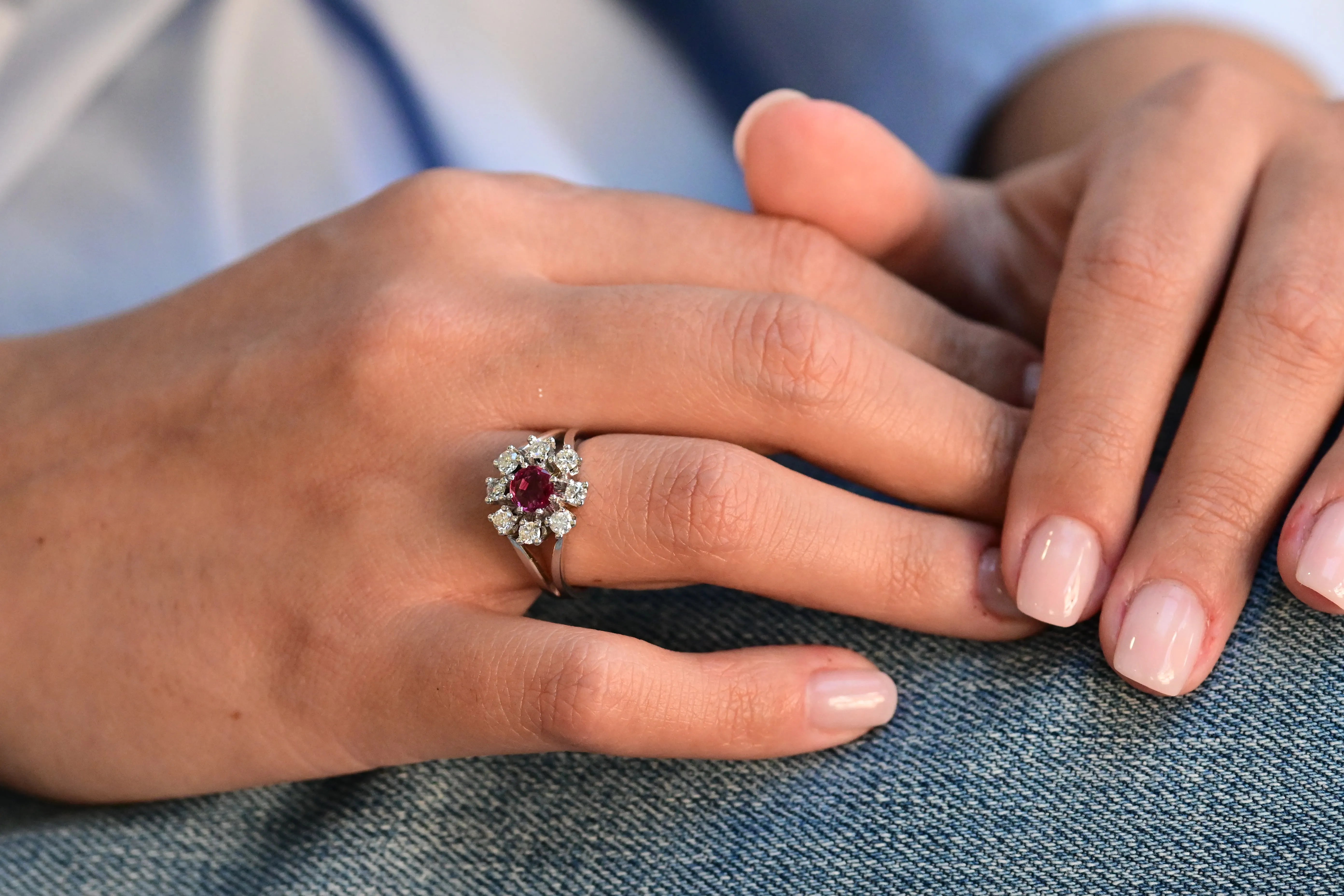 Vintage flower-shaped ring with central ruby and eight natural diamonds in 14K white gold.