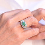 Vintage ring featuring a central teal oval cut emerald and 87 diamonds set in 18K white gold.