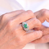 Vintage ring featuring a central teal oval cut emerald and 87 diamonds set in 18K white gold.