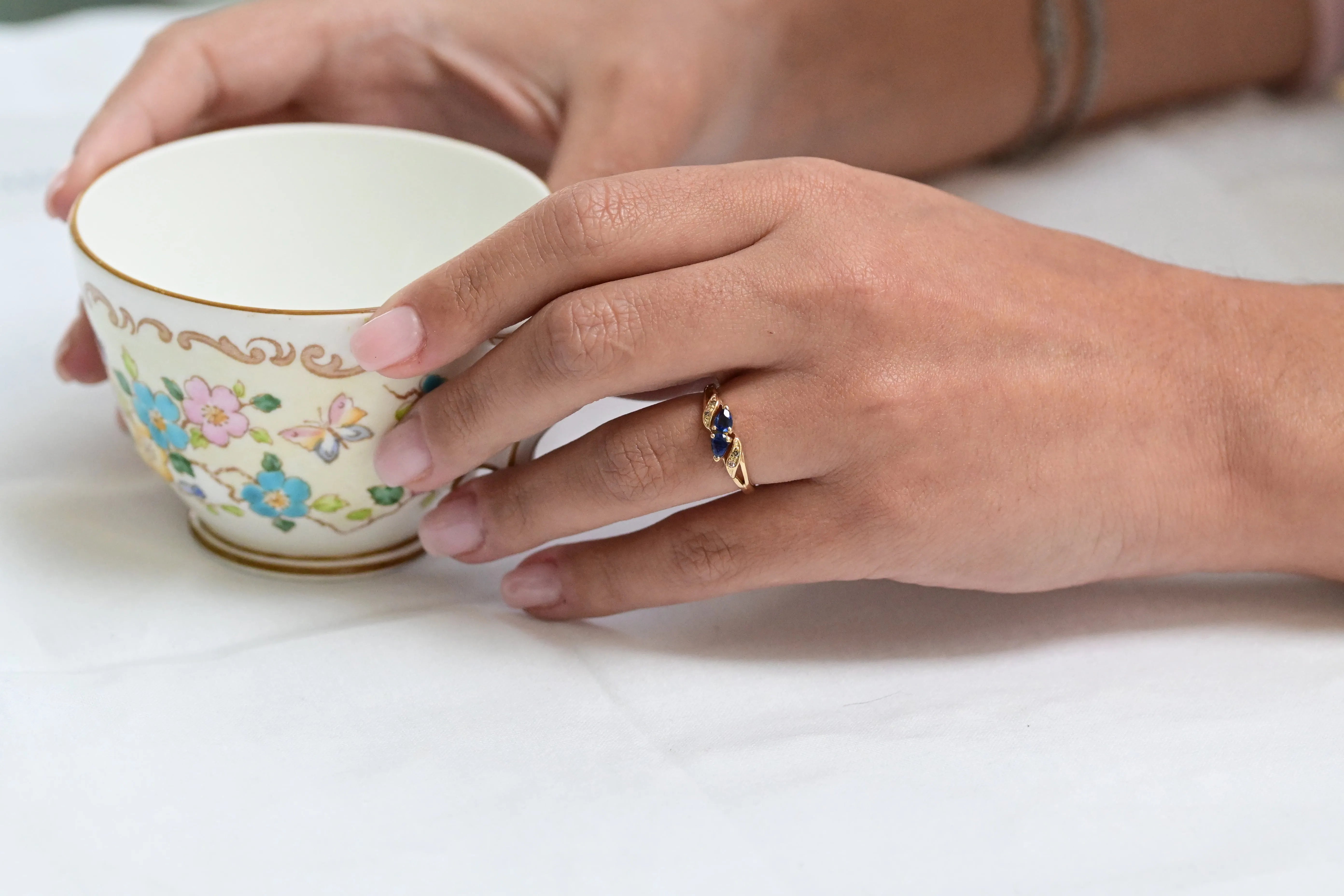 Stunning vintage ring showcasing two pear-cut sapphires in deep blue hues, complemented by four sparkling single-cut diamonds. A timeless piece of elegance perfect for special occasions.