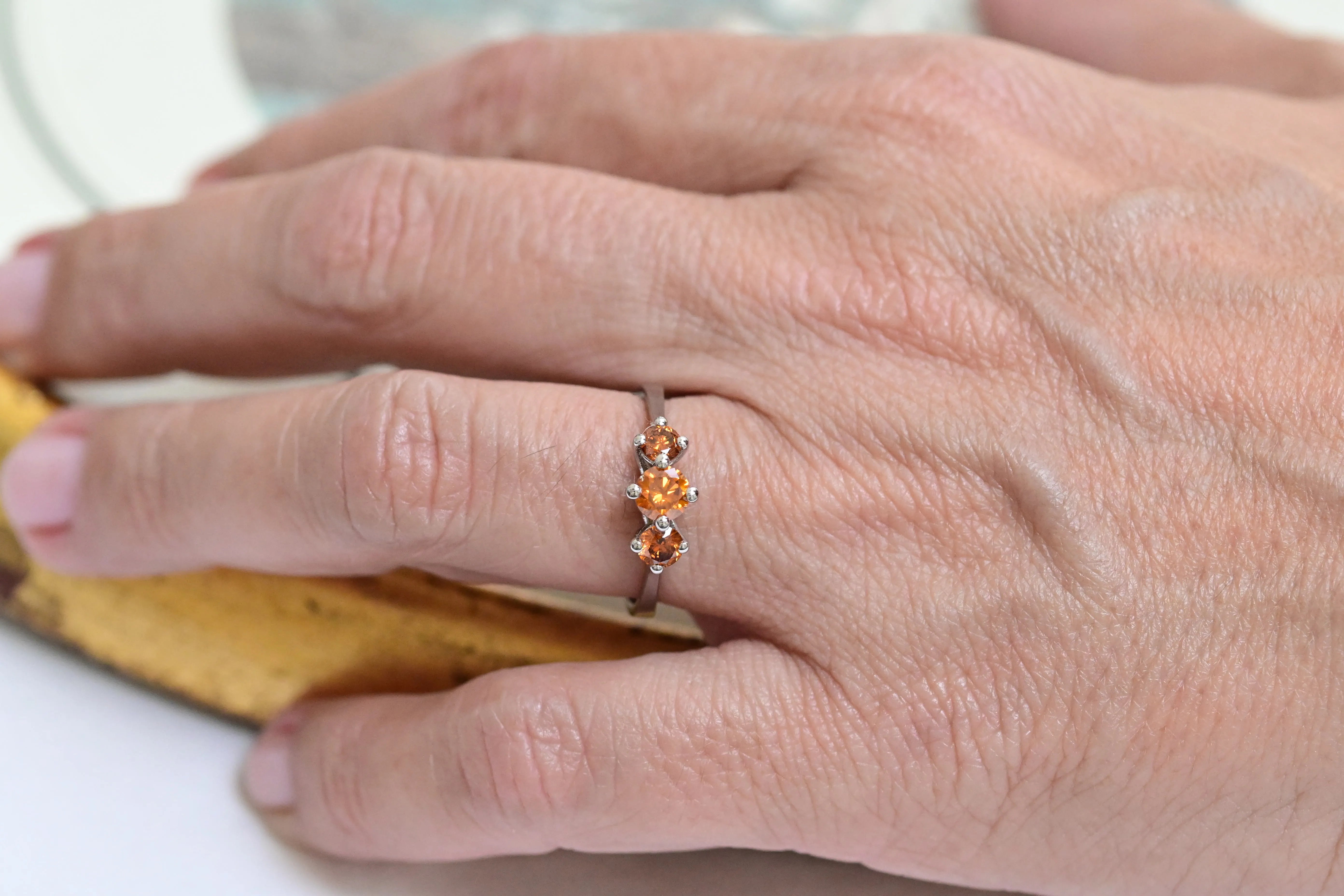 Trinity ring in 18K white gold with 3 fancy vivid orange diamonds.