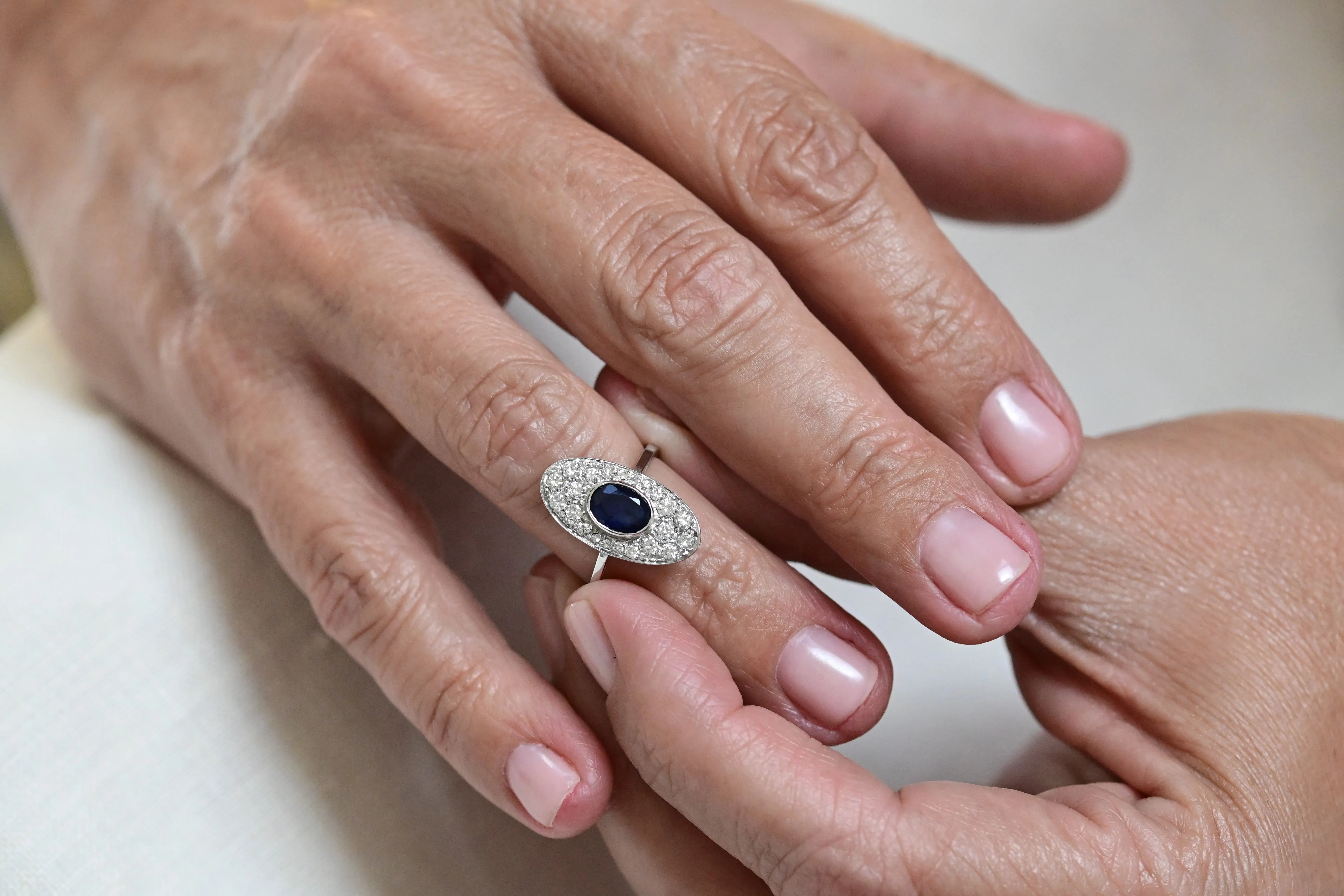 Vintage oval sapphire ring with diamonds, set in 18K white gold.