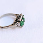 Vintage emerald and diamond ring in 18K white gold with 3 emeralds and 10 diamonds.