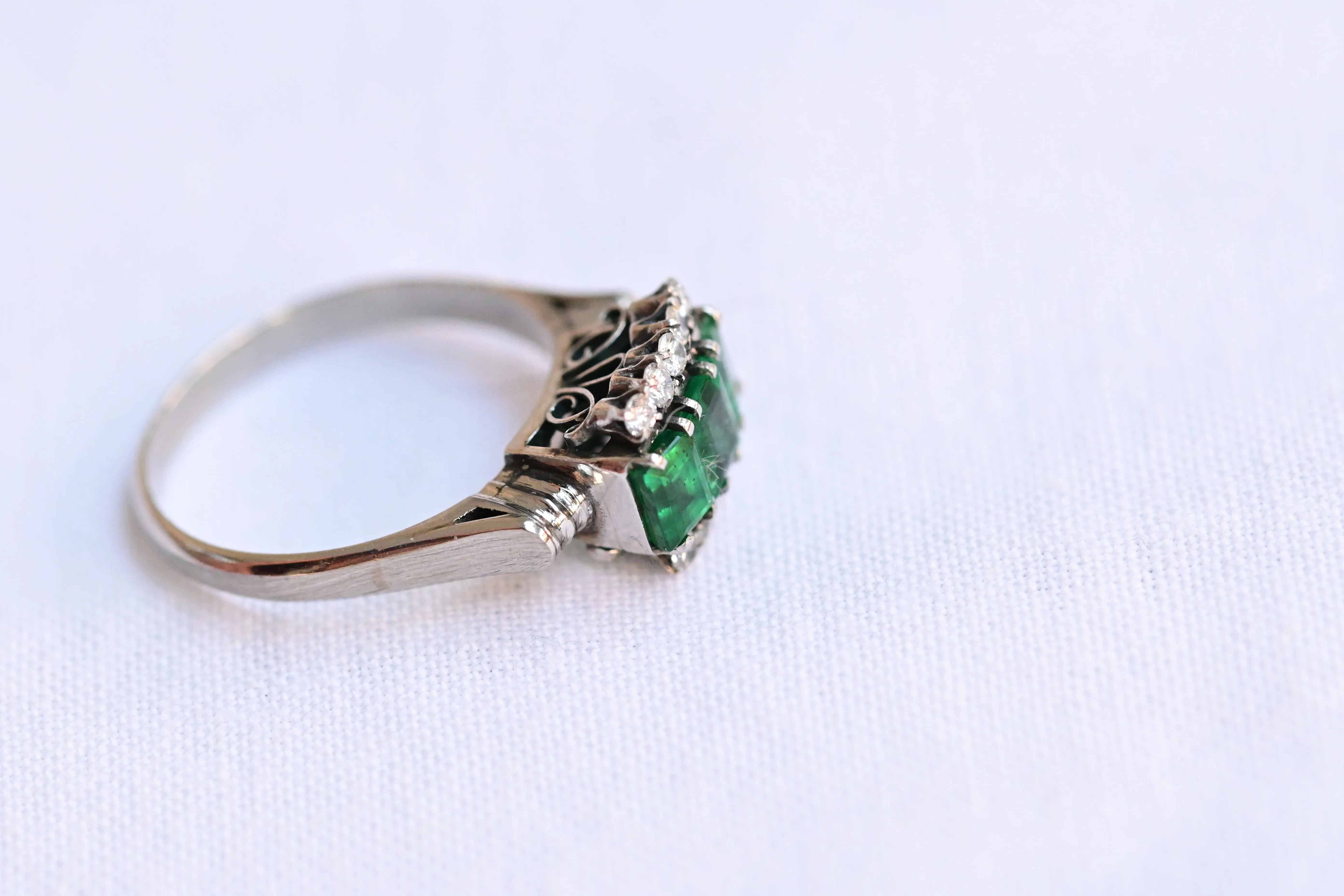 Vintage emerald and diamond ring in 18K white gold with 3 emeralds and 10 diamonds.