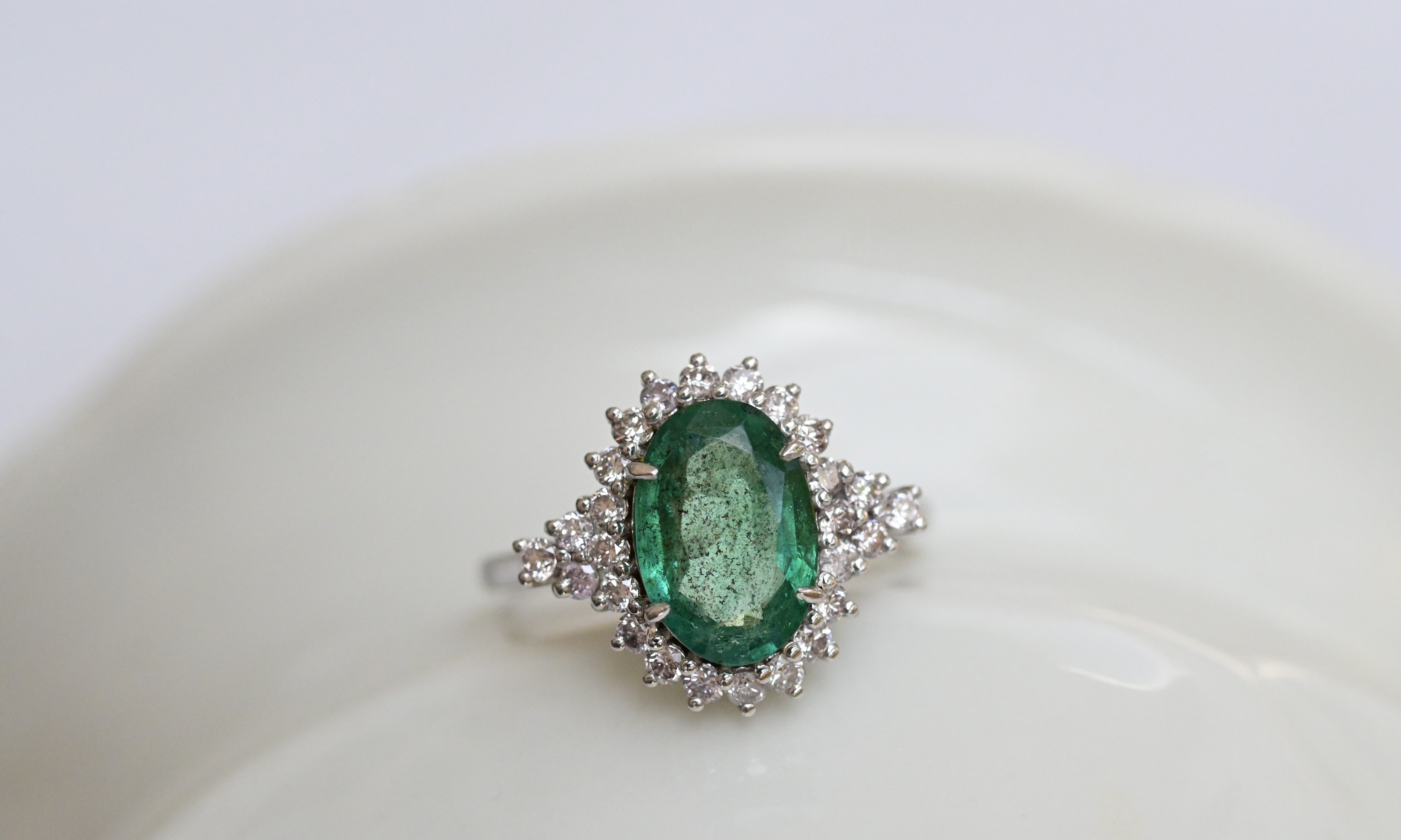 Anillo vintage con un zafiro verde azulado y 26 diamantes corte brillante en oro blanco.