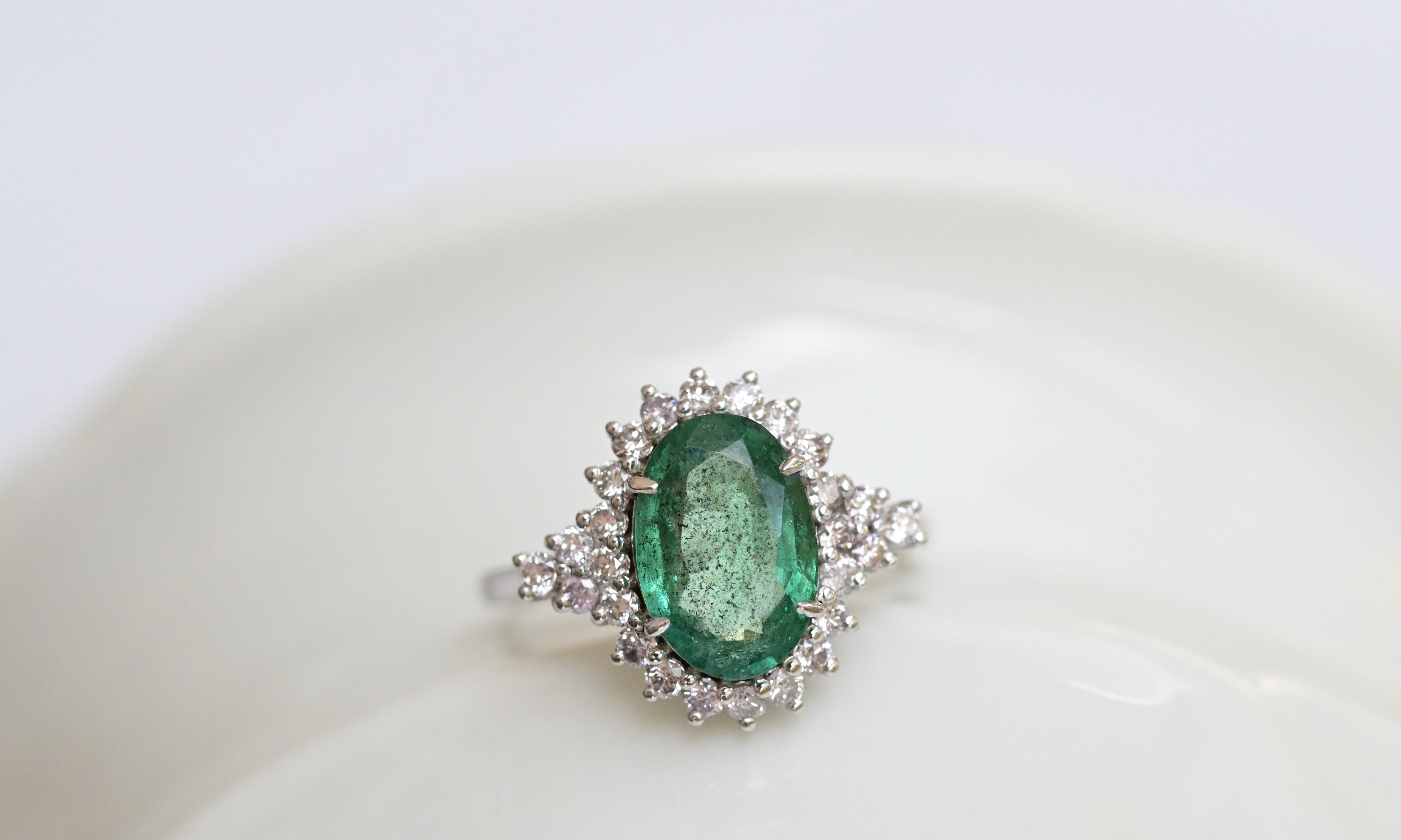 Bague vintage avec une émeraude bleu-vert et 26 diamants taille brillant en or blanc.