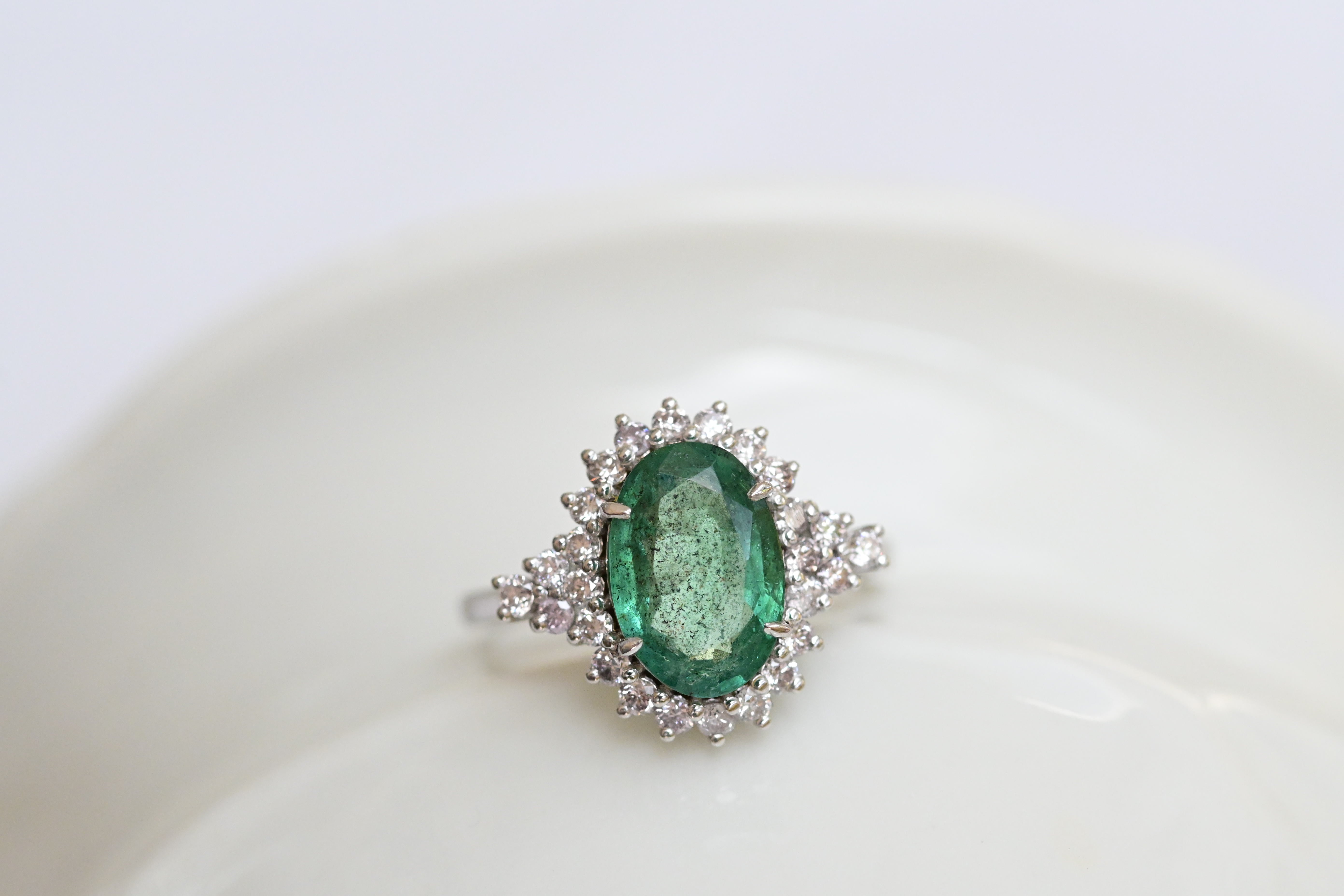 Bague vintage avec une émeraude bleu-vert et 26 diamants taille brillant en or blanc.