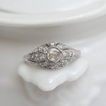 Elegant vintage cocktail ring featuring a central antique cut diamond and 16 eight-cut diamonds, set in white gold.