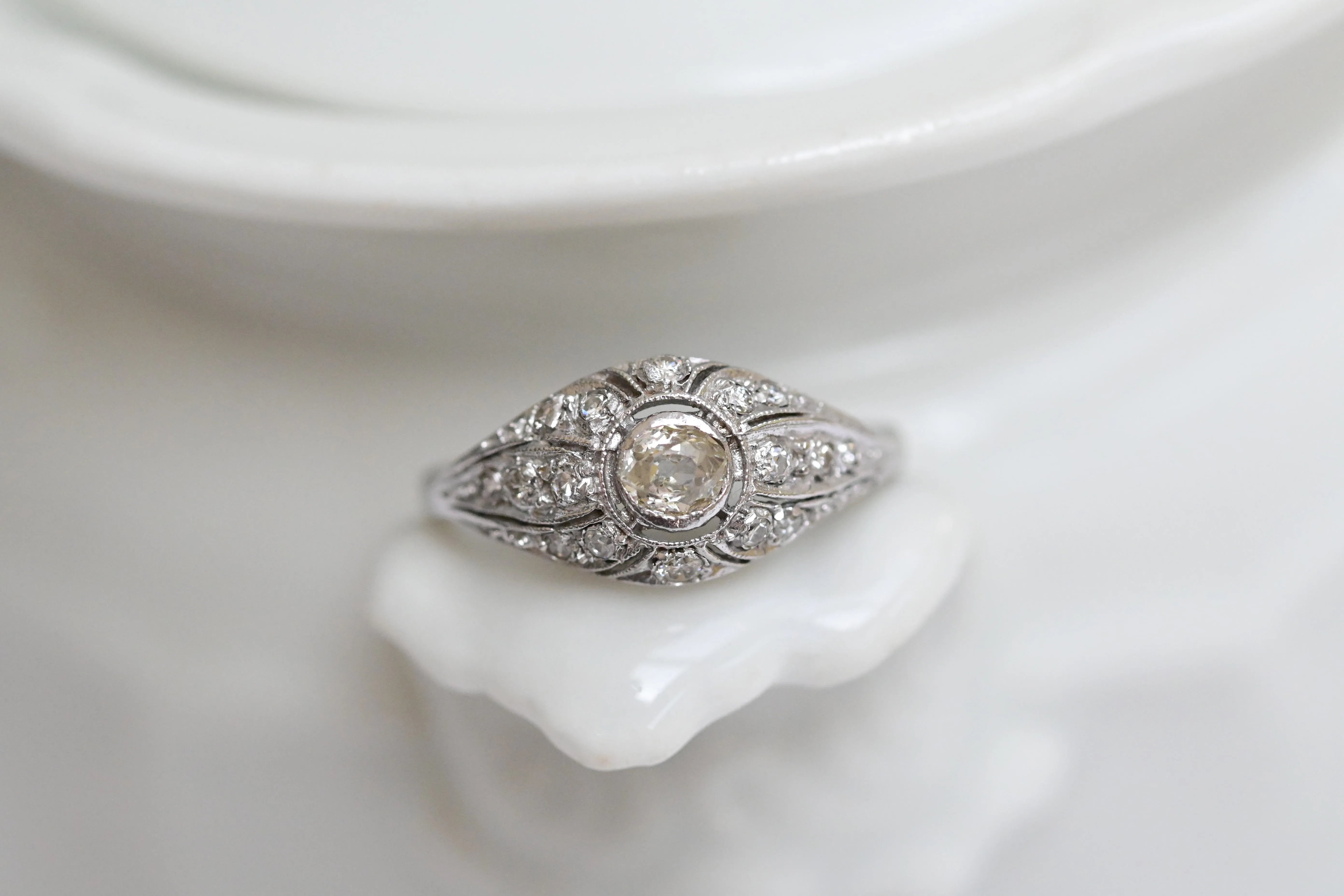 Elegant vintage cocktail ring featuring a central antique cut diamond and 16 eight-cut diamonds, set in white gold.