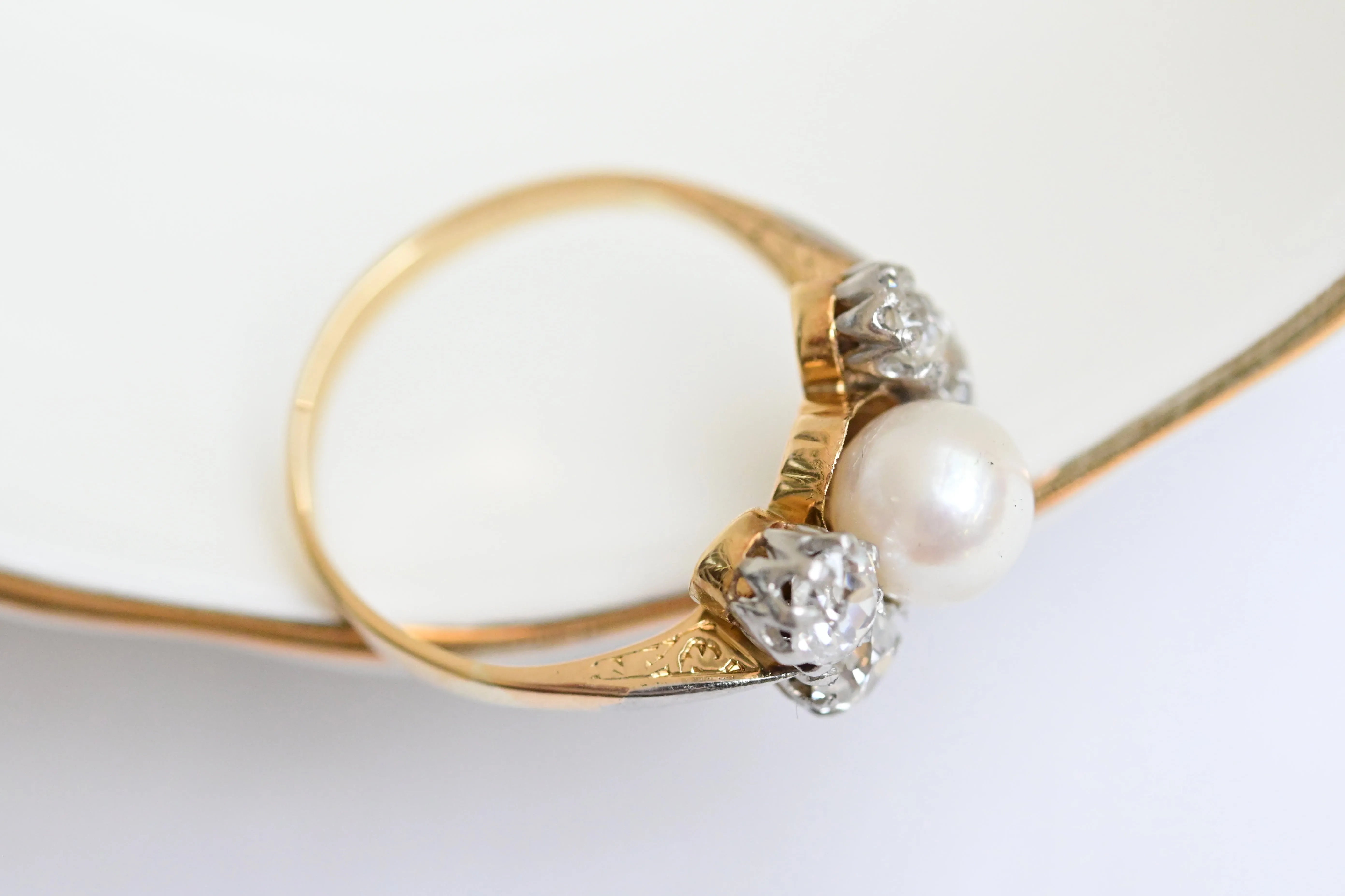 Elegant vintage diamond and pearl ring in yellow gold with European cut diamonds.