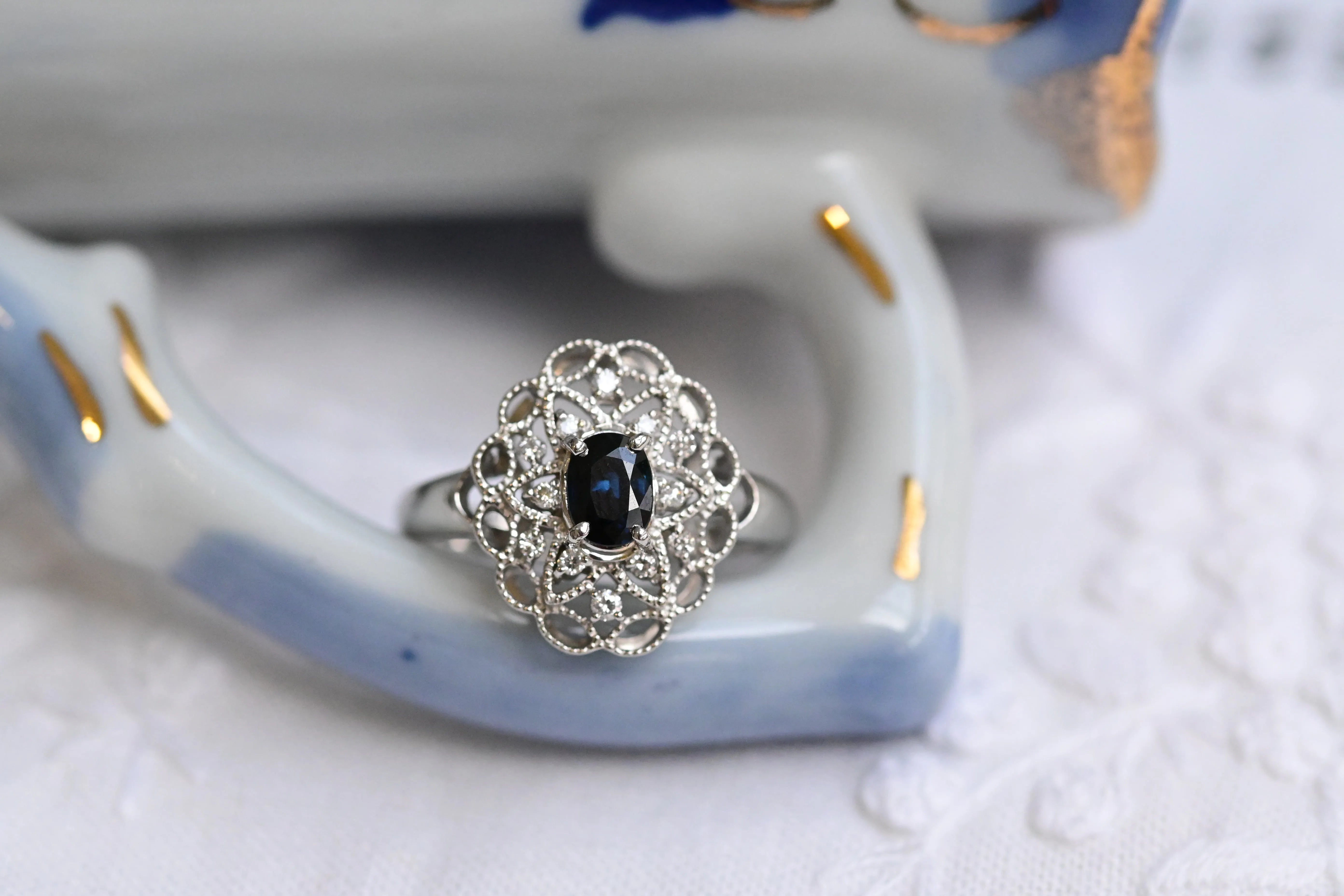 Bague vintage en platine avec saphir ovale et diamants ronds.