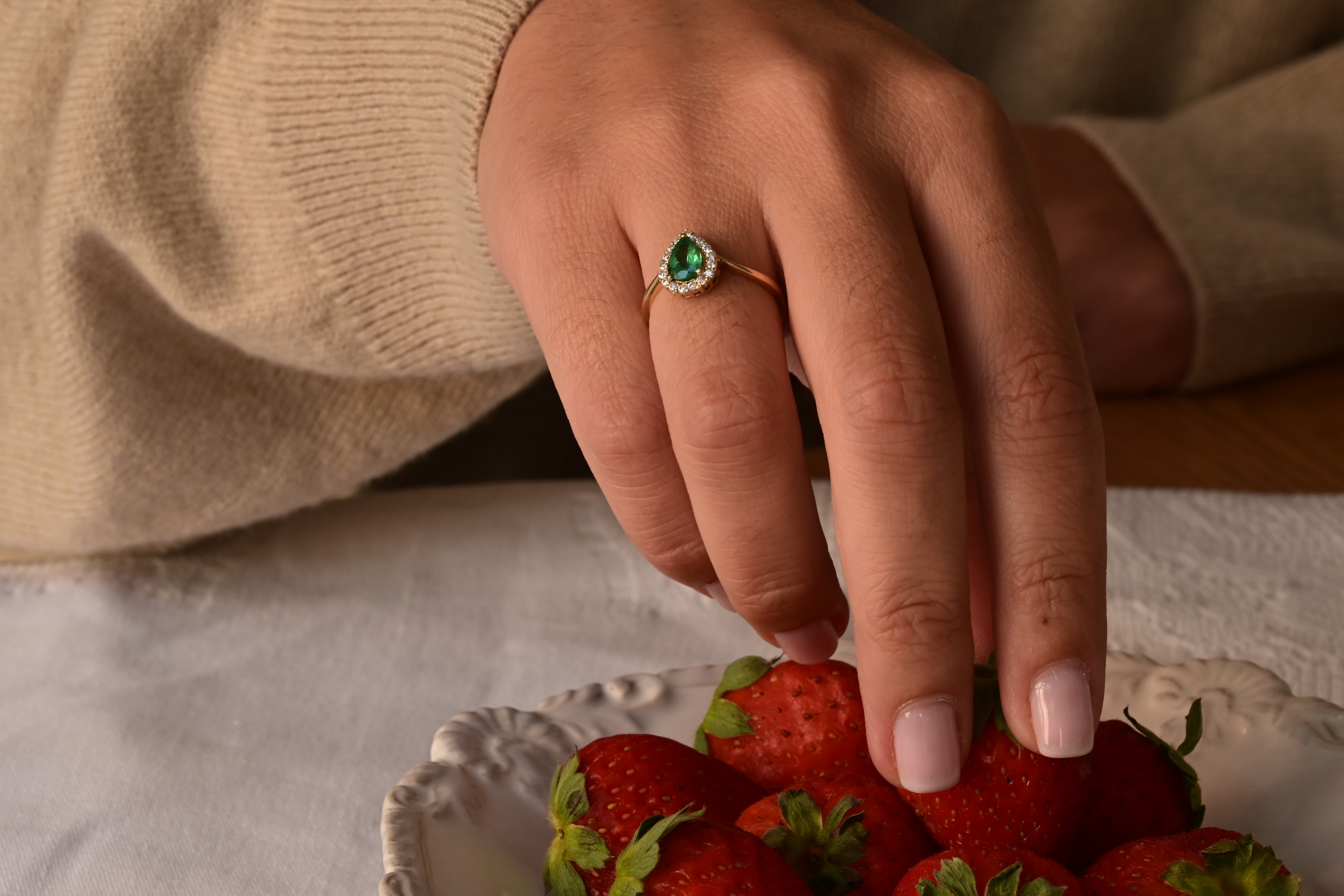 Emerald and diamond ring with pear-cut emerald and 17 diamonds in 14K yellow gold.