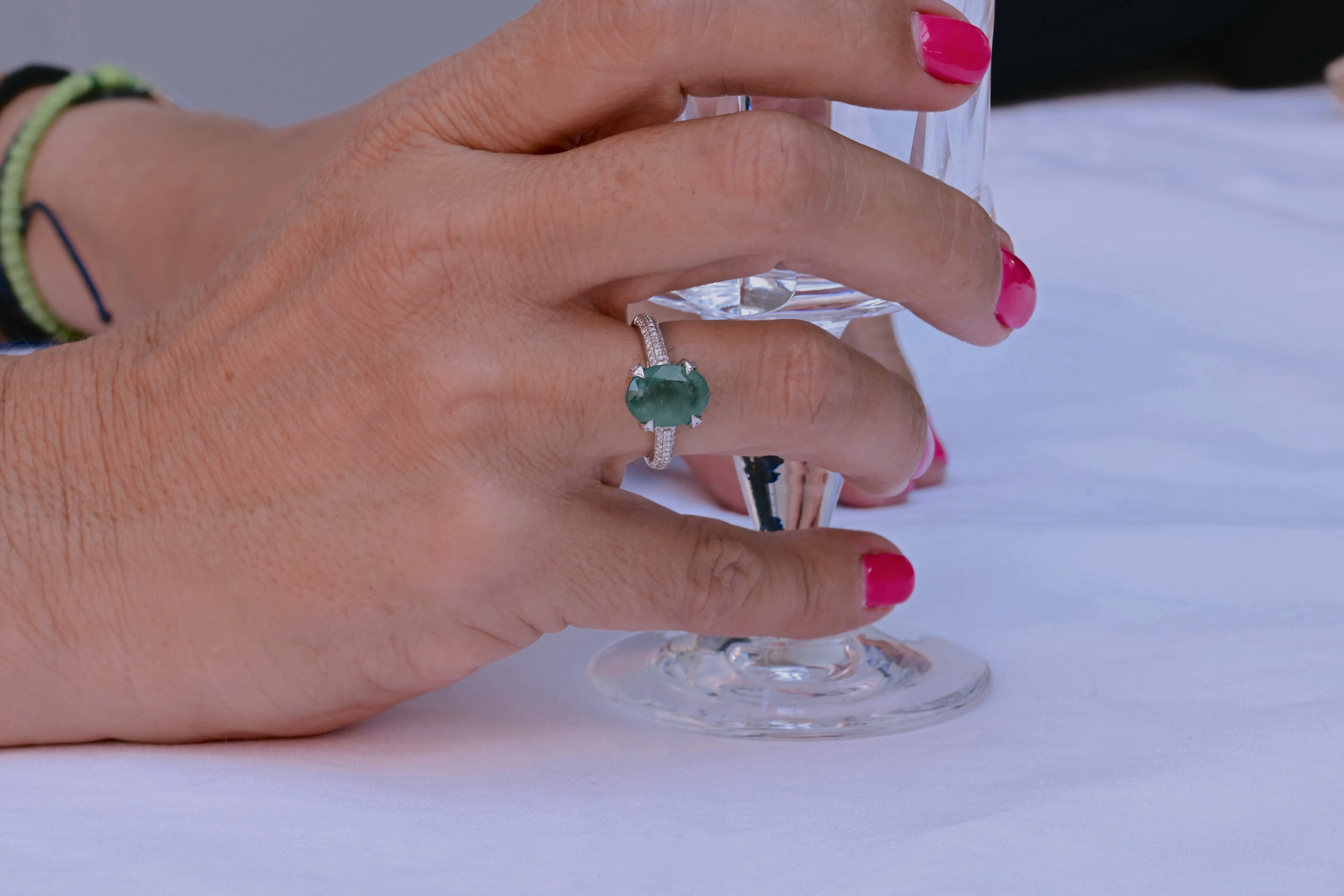 Emerald engagement ring with 3.22 ct green semi-transparent emerald and 86 diamonds in 14K white gold.