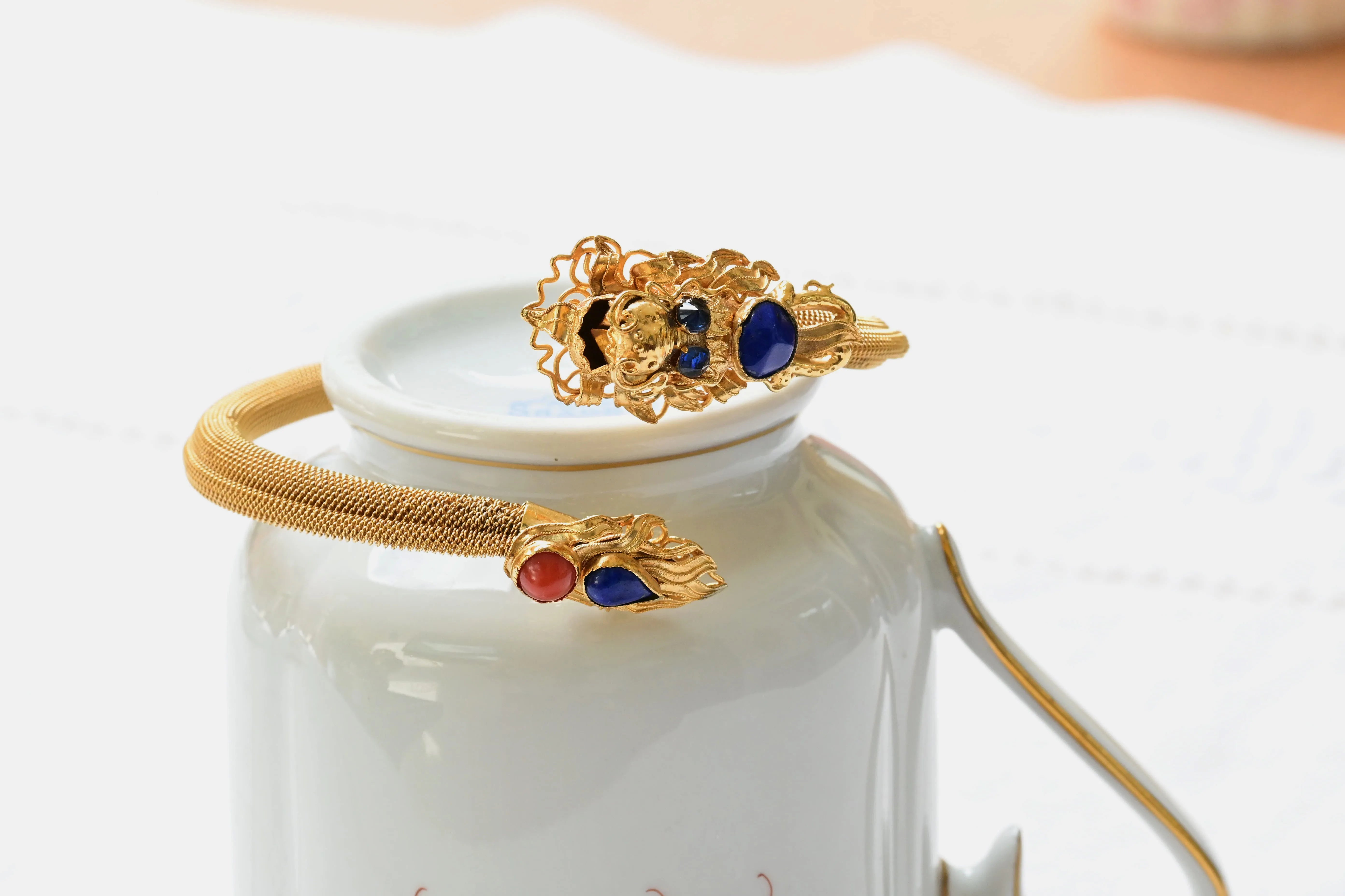 Gold mesh bracelet, with a gold dragon head and tail, and several gemstones set:&nbsp;Sapphires, Lapiz Lazuli and Diamonds.  Handmade vintage jewel.